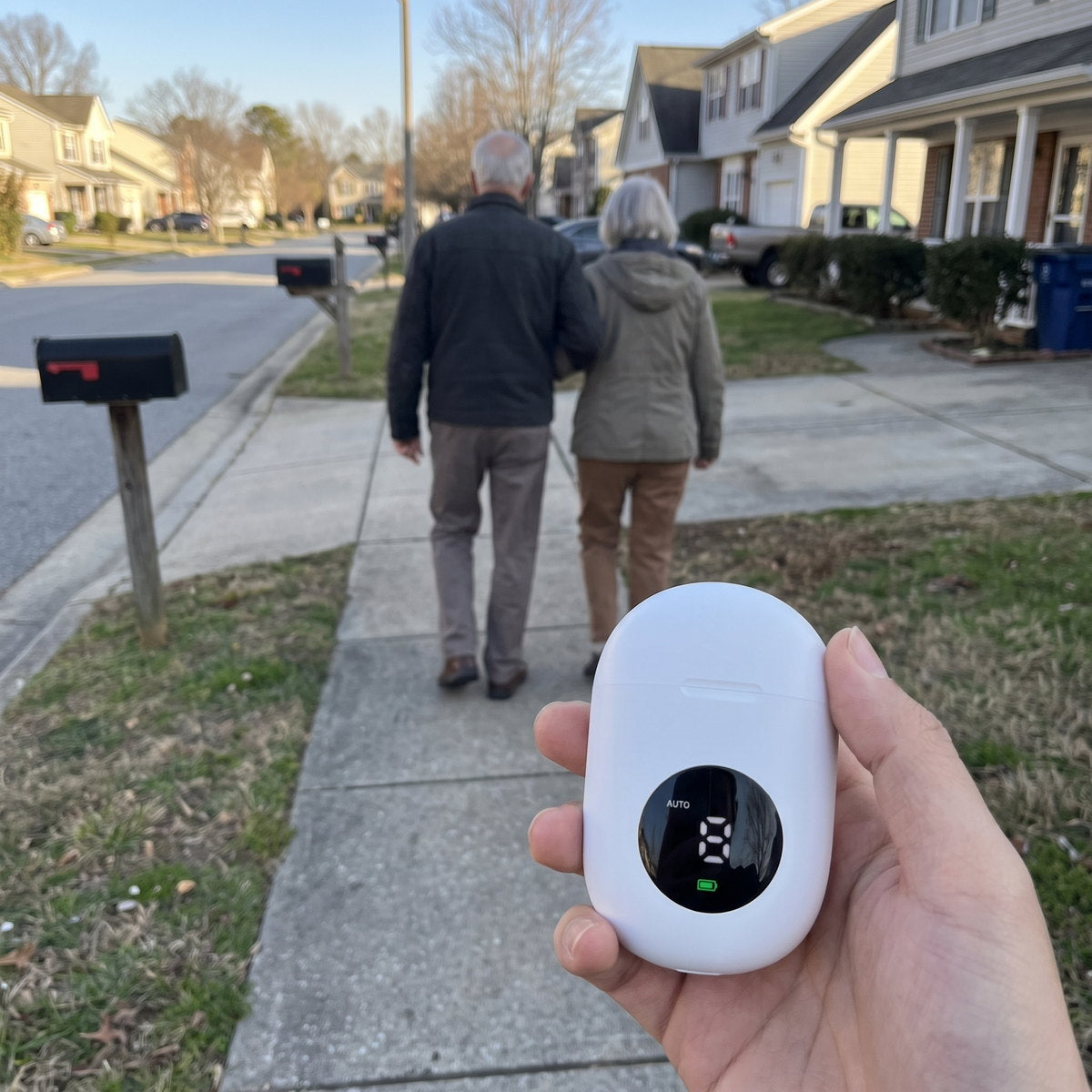 An older couple walking away down a suburban sidewalk.